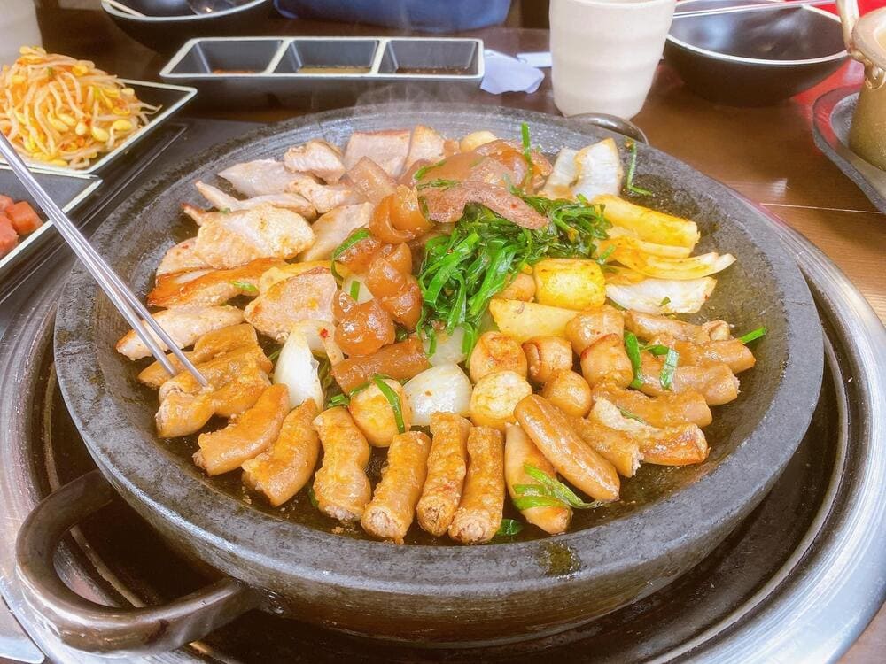 Lòng bò và da heo được tẩm ướp sốt cay đậm đà, nướng nóng giòn trên chảo gang (Nguồn: DAE HAN - Lòng bò nướng Hàn Quốc)